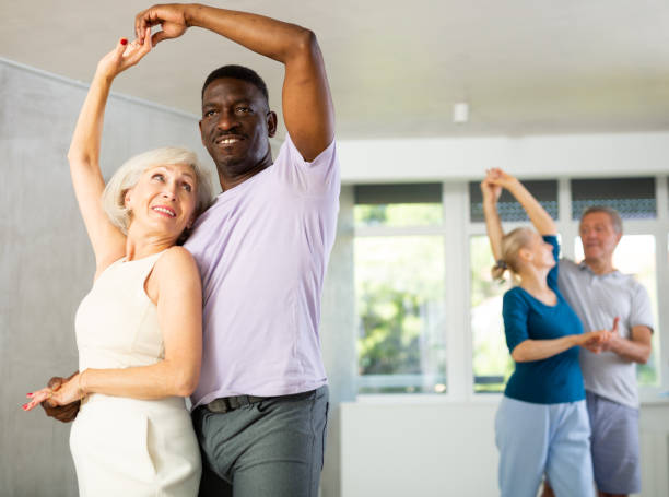 istock Mature men and women practicing Ballroom dances in training room 1499662496