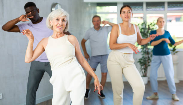 istock Men and women of different ages practicing Rock 'n' Roll dance in training hall 1499662523