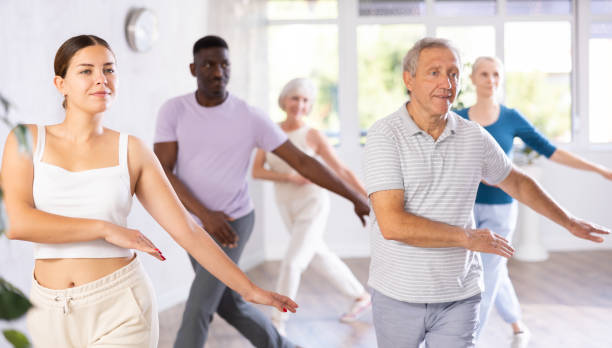 istock Female instructor teaches mature students of dance class basic movements of hip hop dance 1499662690