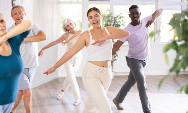 istock Female instructor teaches mature students of dance class basic movements of hip hop dance 1499662739