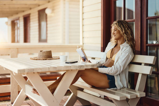 istock Smiling woman reading a book on a patio. 1499662828