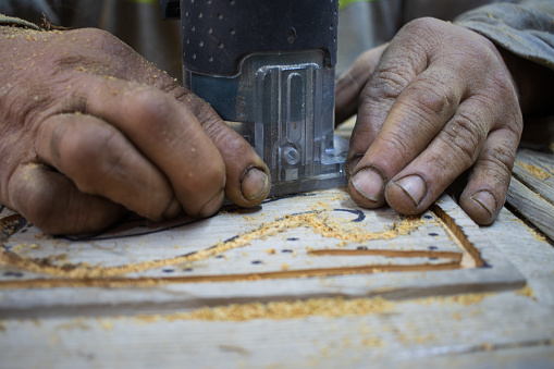 A carpenter mills a wood loft door. High quality photo