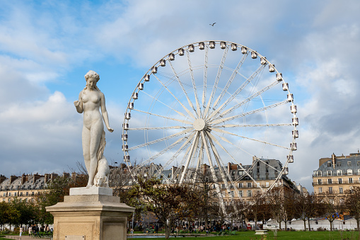 Paris, France - November 22 2022: Big Ferris wheel (Grande roue de Paris) at the Jardin des Tuileries in Paris. Shot in autumn on a cloudy day.