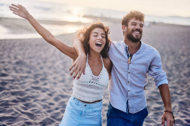 istock Cheerful couple having fun during summer walk on the beach. 1499664371