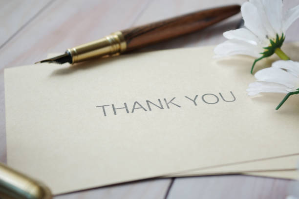 thank you message and envelope on wooden table.