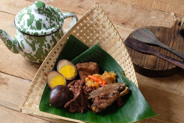 gudeg manggar is a traditional Yogyakarta food made from young jackfruit, egg, chicken, coconut milk, brown sugar, and spices. served in woven bamboo and banana leaf containers. Indonesian food. gudeg manggar is a traditional Yogyakarta food made from young jackfruit, egg, chicken, coconut milk, brown sugar, and spices. served in woven bamboo and banana leaf containers. Indonesian food. gudeg stock pictures, royalty-free photos & images
