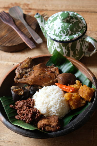 Nasi Gudeg Krecek  is rice and gudeg, which is made from processed young jackfruit, coconut milk, spices, tofu, eggs and chicken. Yogyakarta specialties. Indonesian food. Served with banana leaves. Nasi Gudeg Krecek  is rice and gudeg, which is made from processed young jackfruit, coconut milk, spices, tofu, eggs and chicken. Yogyakarta specialties. Indonesian food. Served with banana leaves. gudeg stock pictures, royalty-free photos & images