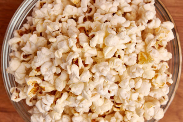 istock A bowl on a wooden background is completely filled with popcorn. 1499668109