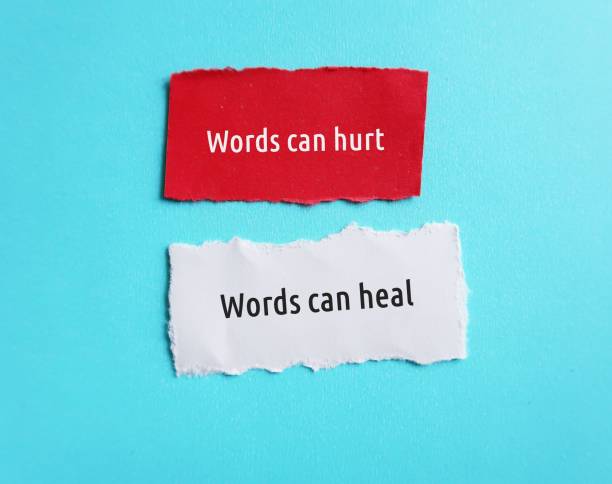 istock Torn paper on blue background with text Words can hurt , Words can heal - to remind language have power to harm or heal - word choice matters most so choose wisely 1499669868