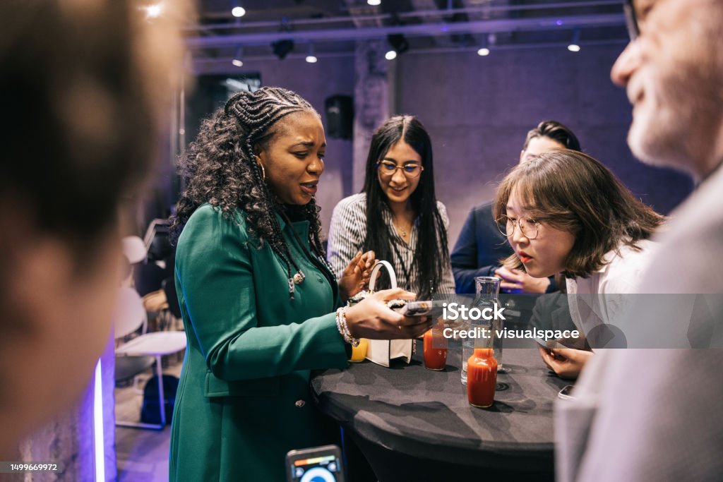 Diversi uomini d'affari si mescolano dopo il successo della conferenza tecnologica. - Foto stock royalty-free di Casual chic Diversi uomini d'affari si mescolano dopo il successo della conferenza tecnologica. - Foto stock royalty-free di Casual chic