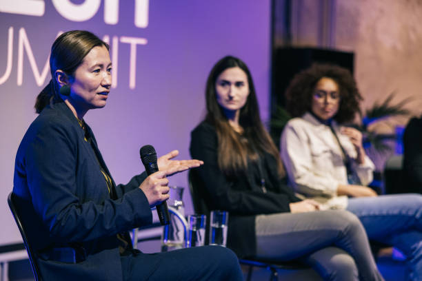 istock Female interviewer interacting with audience and entrepreneurs on stage. 1499670341
