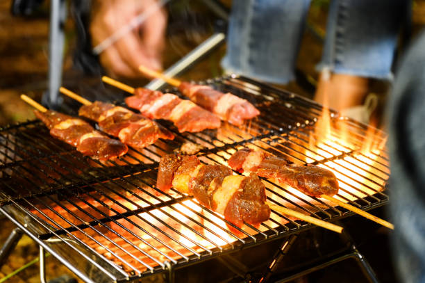 barbecue grillé en gros plan dans le terrain de camping au voyage de camp d’été, brochettes de filet de porc et de bœuf lors d’un dîner barbecue en camping, camp d’été voyagez une activité pour vous détendre. - barbecue grill chef barbecue sausage photos et images de collection