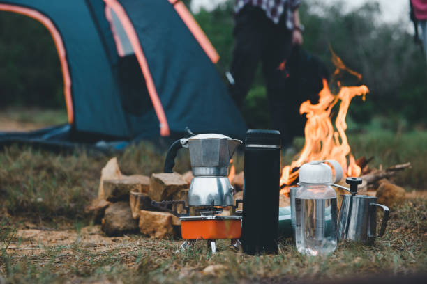 Manual equipment coffee set with bonfire in camping of people camper group in nature near the mountains, Tourism Camping Trip, Outdoor Adventure of Hiking. stock photo