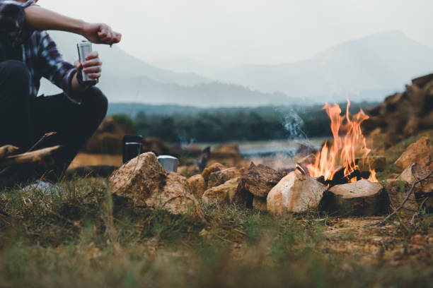 Bonfire in camping of people camper group in nature near the mountains with coffee brewing equipment. stock photo