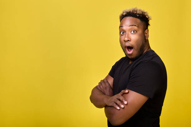 istock Handsome young man stands sideways with worried and surprised expression 1499672782