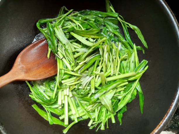 istock Cooking Stir fried Morning Glory vegetable - food preparation. 1499673748