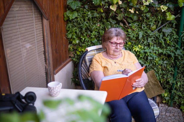 istock Senior user of VR headset writing down her experience 1499678360