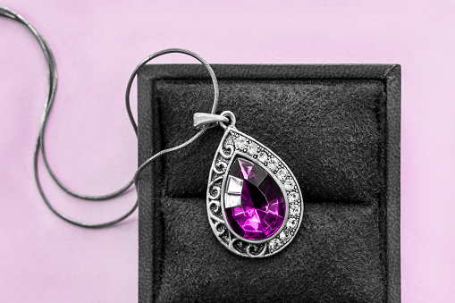 Vintage amethyst pendant necklace in jewel box on lavender background