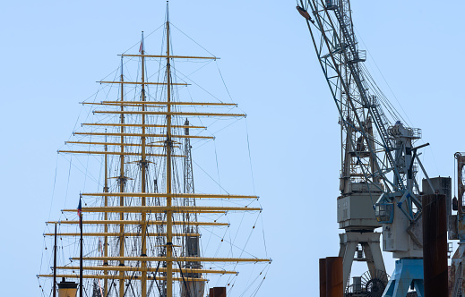 Low angle view of sailing ship and crane against clear sky, Hamburg harbor