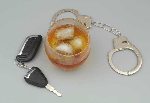 회색 배경에 알코올, 강철 수갑, 자동차 열쇠가 있는 유리. - drunk driving alcohol key law 뉴스 사진 이미지