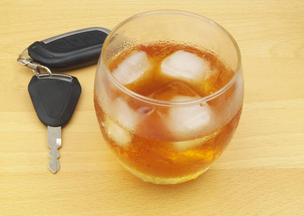 나무 테이블에 알코올이 든 자동차와 유리의 열쇠. - drunk driving alcohol key law 뉴스 사진 이미지
