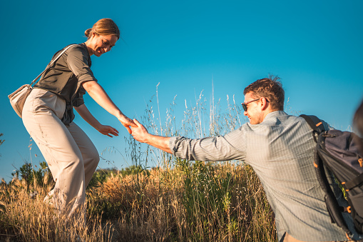 Discovering the wonders of a swamp, a loving mid-adult Caucasian couple, touring as tourists, dives into the adventure, captivated by the enchanting environment.