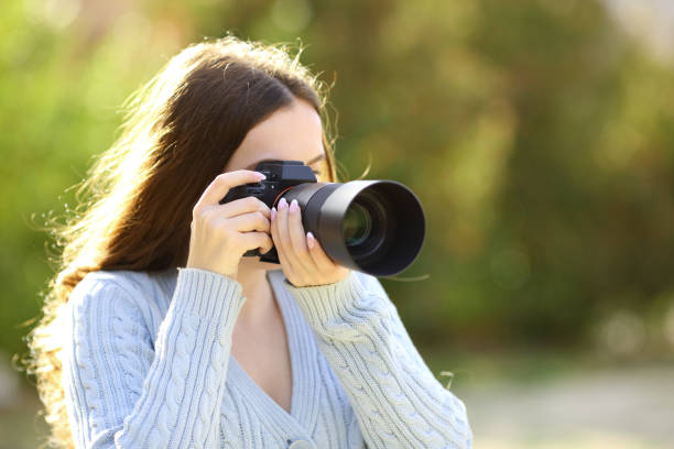istock Photographer taking photos with mirrorless in a park 1499681198