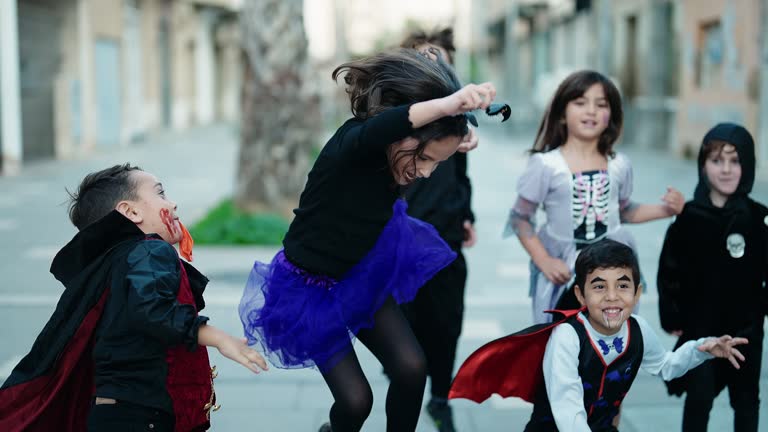 Group of kids wearing halloween costume jumping at street