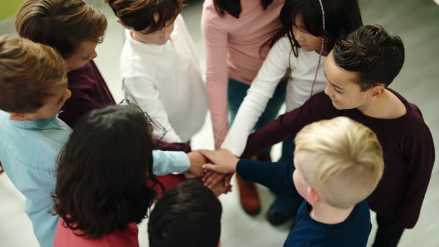 Group of kids students smiling confident with hands together raised up at classroom