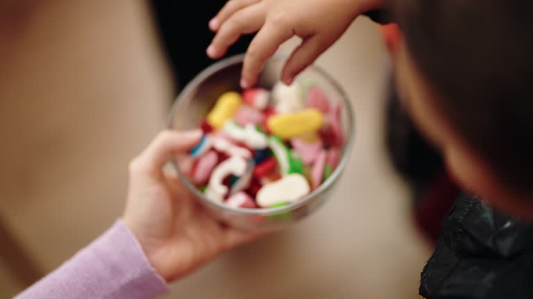 Group of kids wearing halloween costume receiving candies at home