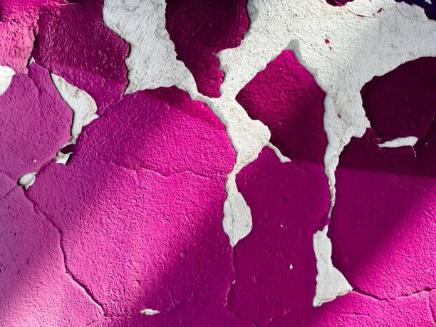 A vibrant purple wall with peeled-off paint.