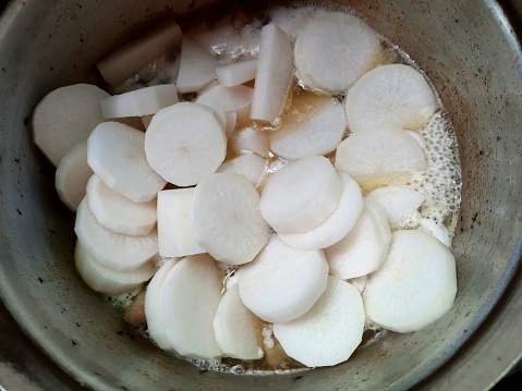 Slices of Radish vegetable in soup- food preparation.