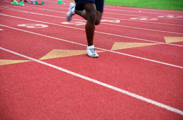 istock Lone runner legs and feet on numbered athletic track 1499687993