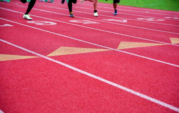 istock Four runners race down a red numbered athletic race track toward te camera 1499688002