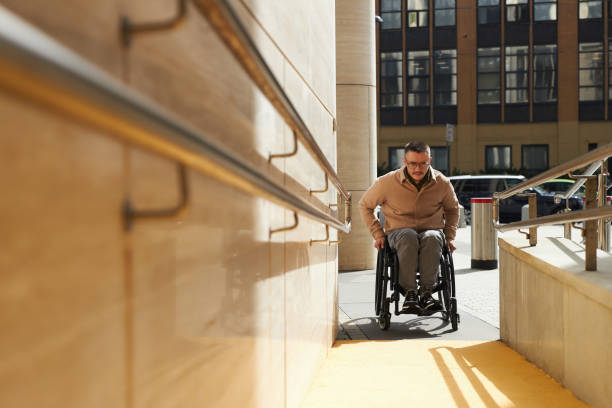 man using ramp to move up - physical impairment wheelchair disabled accessibility imagens e fotografias de stock