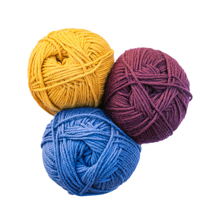 Three balls of yarn - yellow, blue and vinous, isolated on white background. View from above.