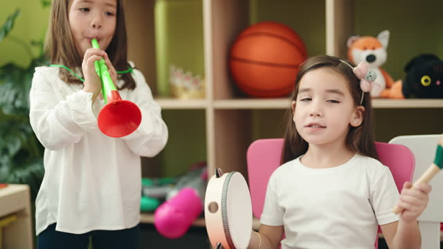 Adorable girls playing instruments at kindergarten