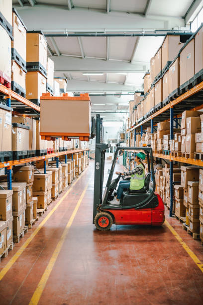 istock Efficient Warehouse Logistics: Young Woman Forklift Driver Moving Boxes onto Truck at Loading Dock in a Factory Warehouse 1499701524