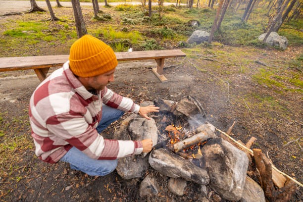 istock Man making fire at campground, he enjoys nature 1499708254