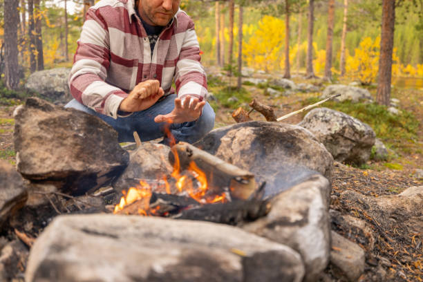istock Man making fire at campground, he enjoys nature 1499708289
