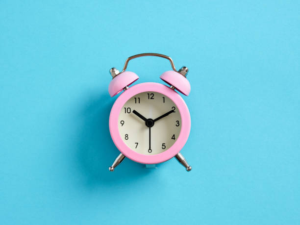 istock Pink alarm clock on blue background. Time management concept. 1499711305