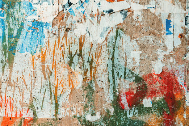 istock Textured surface of torn poster paper on concrete wall as grunge texture and background 1499711928