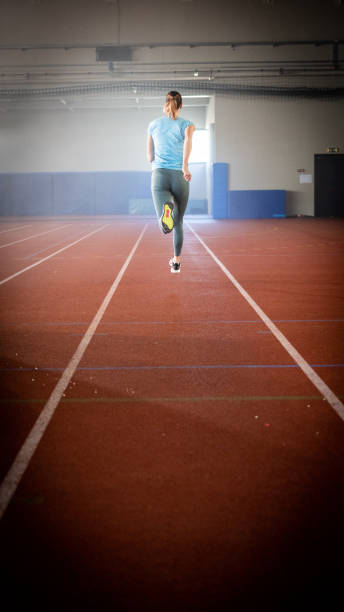 atleta mujer corriendo en pabellón deportivo - long hair rear view brown hair the human body fotografías e imágenes de stock