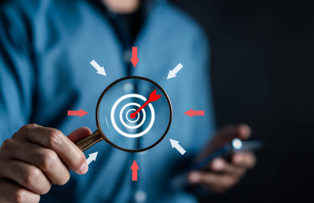 istock Businessman use magnifier glass to aiming objective dart board target with arrow icon. Business goal to success achievement concept. 1499714117