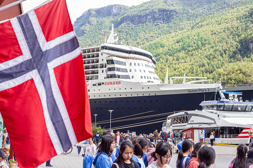 Passengers depart Cunard's Queen Mary 2 moored at the beautiful Fjord port of Flam in Norway to explore the sights and sounds of this stunning area of outstanding natural beauty.
