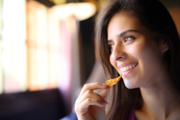 istock Happy restaurant customer eating chips looks at side 1499715669