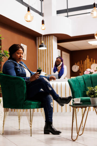 istock Woman sitting at hotel lobby using phone 1499718043