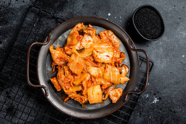 istock Chinese cabbage kimchi in black dish, Korean cuisine. Black background. Top view 1499722010