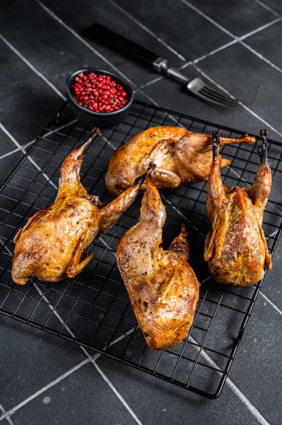 istock Grilled whole quails with herbs and spices. Black background. Top view 1499722688