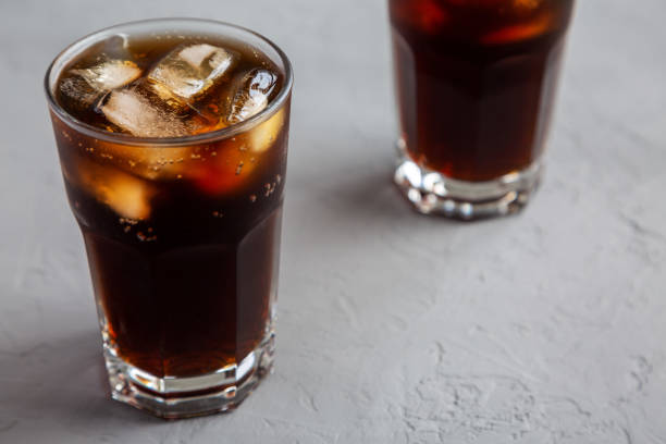 istock Cold Refreshing Dark Cola with Ice Cubes, Straws on a gray surface, side view. 1499725284